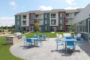 Verona apartment for rent - a patio with tables and chairs in front of an apartment building