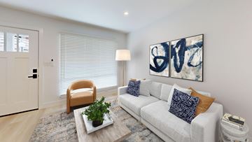 Costa Mesa apartment for rent - A living room with a white couch, a plant on a coffee table, and a painting on the wall.