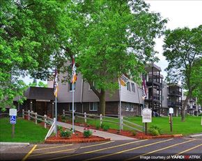 Shoreview apartment for rent - a building with flags and trees in front of it