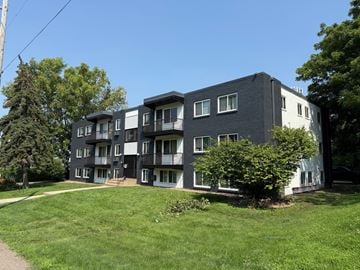 Columbia apartment for rent - A black and white apartment building with a green lawn in front.