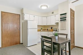 Highland Park apartment for rent - a kitchen with a table and chairs and a refrigerator