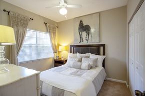 Gainesville apartment for rent - a bedroom with a large bed and a painting of a horse