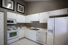 Gainesville townhouse for rent - a kitchen with white appliances and white cabinets