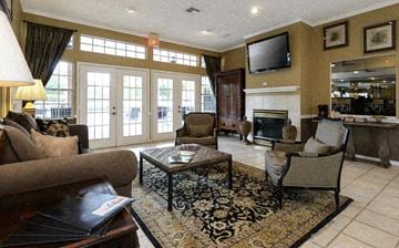 Gainesville apartment for rent - a living room with couches and chairs and a fireplace