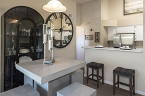 Gainesville apartment for rent - a kitchen with a large clock on the wall and a counter with stools