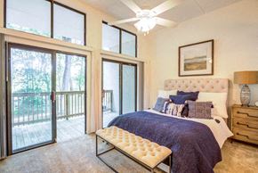 Gainesville townhouse for rent - a bedroom with a bed and sliding glass doors to a balcony