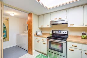 Gainesville townhouse for rent - a kitchen with white cabinets and a green oven and stove