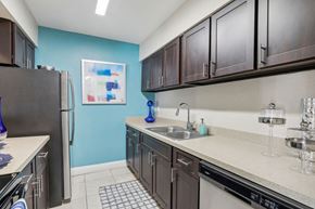 Winter Park apartment for rent - A kitchen with a black refrigerator and brown cabinets.