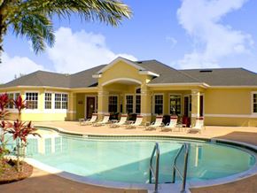 Orlando apartment for rent - a swimming pool with chairs in front of a house