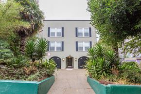 San Francisco apartment for rent - A grey building with a green border around the plants.