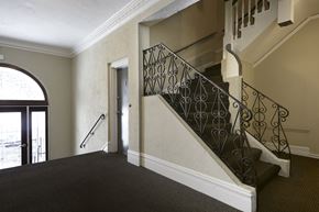 San Francisco apartment for rent - A staircase with a metal railing and a carpeted floor.