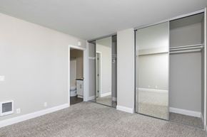 Carlsbad apartment for rent - an empty bedroom with mirrored closet doors and a bathroom
