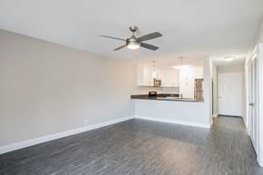 Carlsbad apartment for rent - an empty living room with a ceiling fan and a kitchen