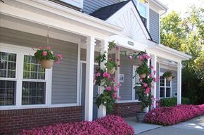 Ypsilanti apartment for rent - the front porch of a house with two hanging baskets of flowers