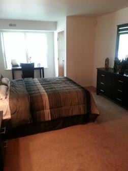Detroit apartment for rent - A bedroom with a bed, dresser and mirror.