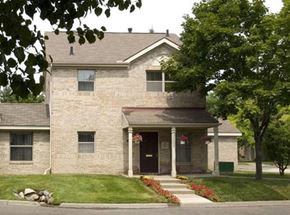 Detroit apartment for rent - A house with a front porch and a tree in front.