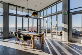 Seattle apartment for rent - a dining area with a wooden table and chairs and a view of the ocean from