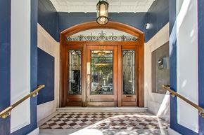 San Francisco apartment for rent - A wooden door with glass panels and a sign above it that reads "990".