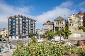 San Francisco apartment for rent - A street view of a city with a large building on the left and a few smaller ones on the right.