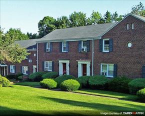 Caldwell apartment for rent - A red brick house with green bushes in front.