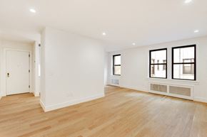 Brooklyn apartment for rent - the living room and dining room of a house with white walls and wood floors