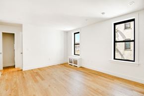Brooklyn apartment for rent - an empty living room with wood floors and a large window