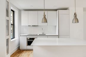 Brooklyn apartment for rent - a white kitchen with stainless steel appliances and white cabinets