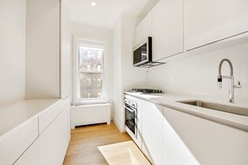 Brooklyn apartment for rent - A modern kitchen with white cabinets and a stainless steel sink.