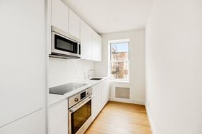 Brooklyn apartment for rent - A kitchen with white cabinets and a window.