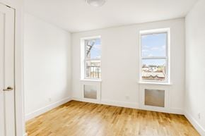 Brooklyn apartment for rent - an empty room with wood floors and two windows