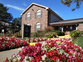Northville apartment for rent - the front of a brick building with colorful flowers