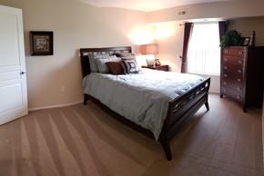 Northville apartment for rent - a bedroom with a bed and a dresser and a window