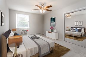Philadelphia apartment for rent - Furnished model of Master Bedroom with ceiling fan, mirror closet doors, and air conditioner installed in the wall under window.