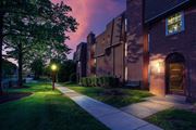 Huntingdon Valley apartment for rent - Exterior of one of the buildings at night, showing landscaped grass, hedges, and walkway