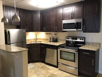 Jenkintown apartment for rent - A kitchen with dark brown cabinets and stainless steel appliances.