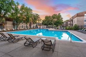 Norristown apartment for rent - Swimming pool at sunset with chaise lounge chairs lined up on the pool deck