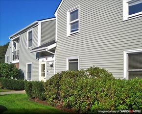 Duxbury apartment for rent - a gray house with bushes in front of it
