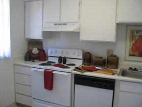 Albuquerque apartment for rent - A white kitchen with a red towel on the stove.