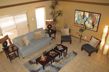 Albuquerque apartment for rent - A living room with a grey couch, a coffee table, and a painting on the wall.