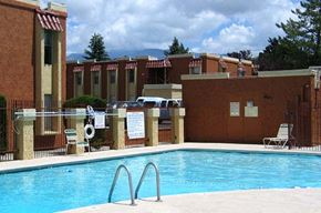 Albuquerque apartment for rent - A pool surrounded by a fence and chairs.