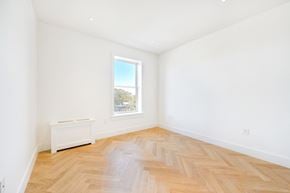 Brooklyn apartment for rent - a living room with white walls and wooden floors and a window