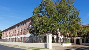 Austin apartment for rent - a large brick building with a tree in front of it
