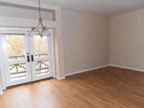 Austin apartment for rent - an empty living room with a wooden floor and a door to a balcony