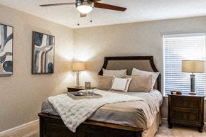 Noblesville apartment for rent - A bedroom with a bed, nightstand, and two lamps.