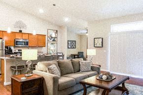 Greer apartment for rent - A living room with a couch, a coffee table, and a kitchen area in the background.