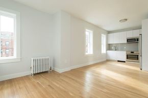 Boston apartment for rent - an empty living room and kitchen with a wood floor