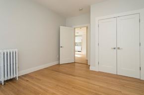 Boston apartment for rent - a bedroom with a radiator and a door to a hallway