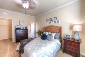 Jacksonville apartment for rent - A bedroom with a bed, nightstand, and a ceiling fan at Cabana Club Apartments, Jacksonville, 32256