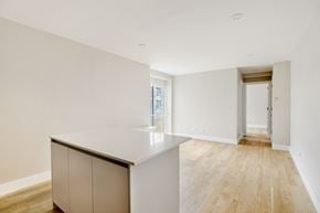 Brooklyn apartment for rent - a living room and kitchen with white walls and wood floors