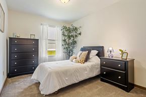 Grandville apartment for rent - A bedroom with a bed, nightstand, and dresser.